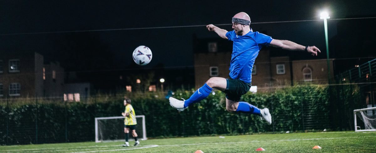 A player wearing Prevolve cleats on the field at night